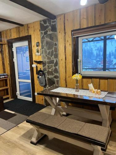 a table in a room with a stone wall at Файна хата 2 in Synevyrsʼka Polyana