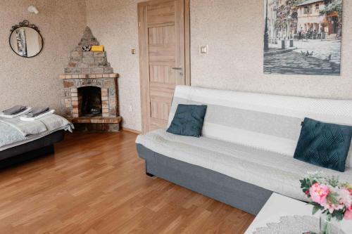 a living room with a couch and a fireplace at Mira - Mira pokoje z widokiem na jezioro in Chmielno