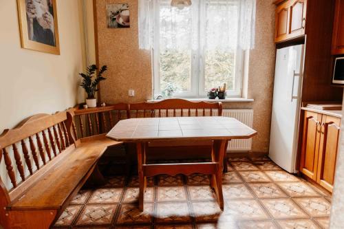 a kitchen with a table and chairs and a window at Mira - Mira pokoje z widokiem na jezioro in Chmielno