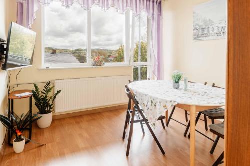 a dining room with a table and a window at Mira - Mira pokoje z widokiem na jezioro in Chmielno