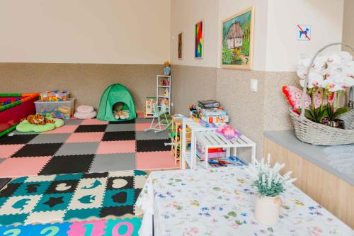 a toy room with a table and a play area at Mira - Mira pokoje z widokiem na jezioro in Chmielno