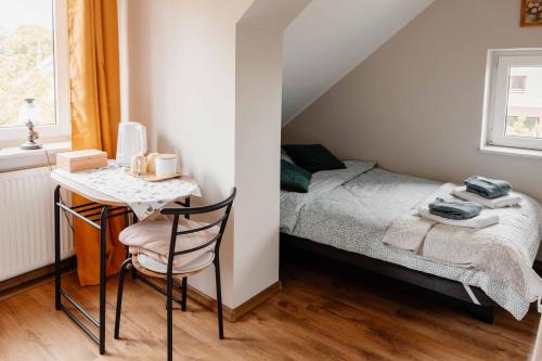 a small bedroom with a bed and a desk at Mira - Mira pokoje z widokiem na jezioro in Chmielno