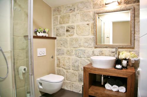 une salle de bains avec lavabo, toilettes et miroir dans l'établissement Magnolia Luxury Apartments, à Split