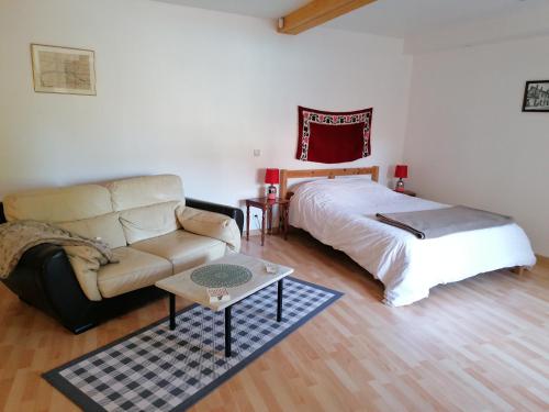 une chambre avec un lit, un canapé et une table dans l'établissement La Grange du Layon, à Saint-Georges-sur-Layon