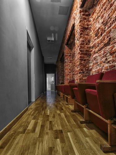 an empty room with chairs and a brick wall at Cinema Rooms - Piotrkowska in Łódź