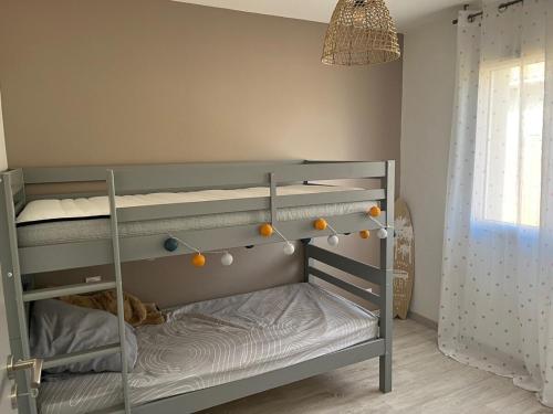 une chambre avec un lit superposé avec une échelle dans l'établissement Villa au Teich cœur du Bassin d Arcachon 3 chambres, au Teich