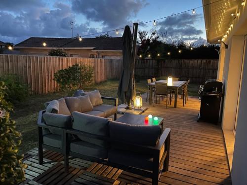 un patio avec un canapé et une table sur une terrasse dans l'établissement Villa au Teich cœur du Bassin d Arcachon 3 chambres, au Teich