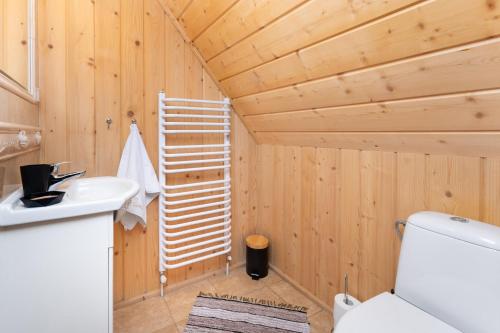a bathroom with a toilet and a wooden ceiling at Domki i Apartamenty Krupa Ciche z Jacuzzi in Zakopane