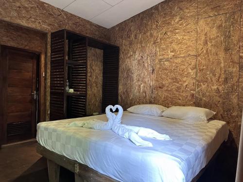 a bedroom with a bed with two swans on it at Telaga Warna in Tengahgirang