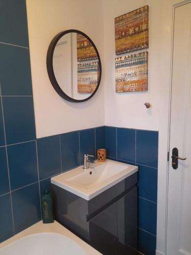 a bathroom with a sink and a mirror at Double room, living space and bathroom, in a family home, near Ulverston in Pennington