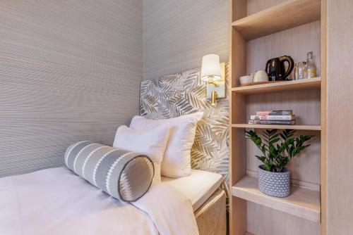 a small bedroom with a bed with white pillows at Home Hotel Wellington in Stockholm