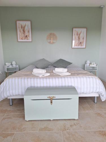 un lit blanc avec deux serviettes dessus dans l'établissement Mon Eden - Gite Le Verdet, à Meynes