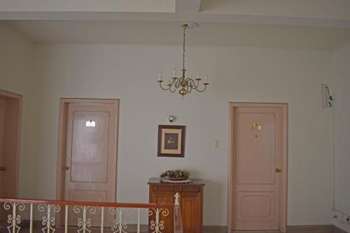 a hallway with two doors and a chandelier at Hotel Bresciani in La Aurora