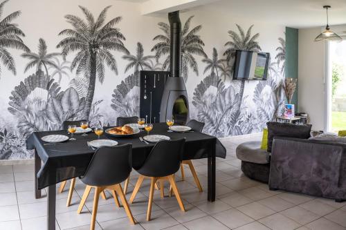 ein Esszimmer mit Tisch und Kamin in der Unterkunft La Brocéliande enchantée in Iffendic