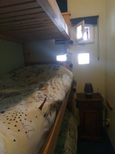 - une chambre avec des lits superposés et un cadre en bois dans l'établissement Comfortable and charming studio Foux d Allos Centre 4 pers, à Allos