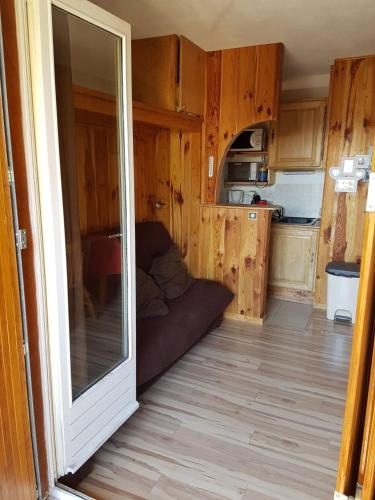 - un salon avec une porte coulissante en verre menant à une cuisine dans l'établissement Comfortable and charming studio Foux d Allos Centre 4 pers, à Allos