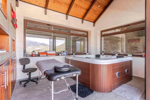 a bathroom with a tub and a table and a stool at Casa Chely in Alcaucín
