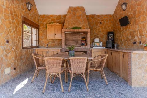 a kitchen with a table and chairs in a room at Casa Chely in Alcaucín
