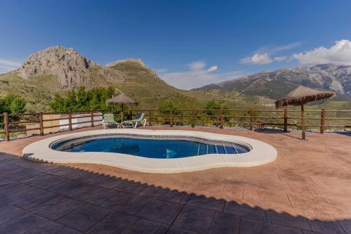 a swimming pool in a patio with mountains in the background at Casa Chely in Alcaucín