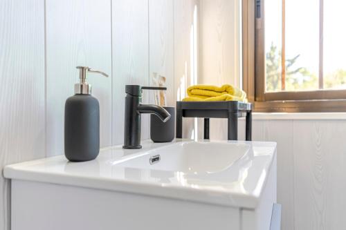 a bathroom sink with a soap dispenser on it at Casa Chely in Alcaucín