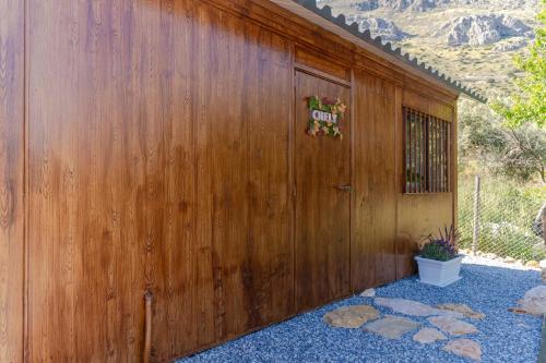 a wooden building with a door with a sign on it at Casa Chely in Alcaucín