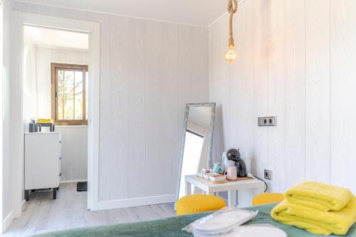 a room with a mirror and a table with yellow chairs at Casa Chely in Alcaucín