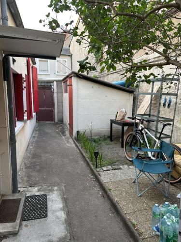 un vélo garé devant une maison avec un bâtiment dans l'établissement Studio Orléans, à La Celle-sous-Gouzon