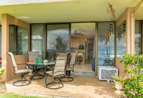 a patio with a table and chairs on a patio at Maalaea Banyans 102 by Coldwell Banker Island Vacations in Wailuku