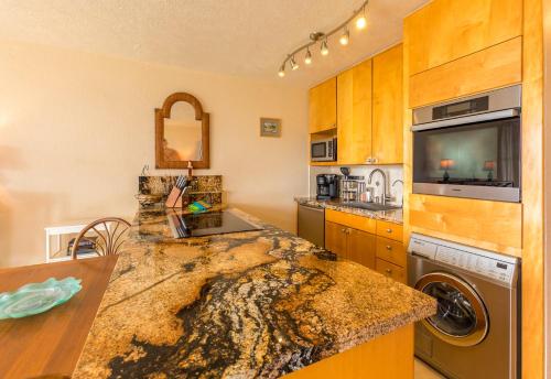 a kitchen with a sink and a dishwasher at Maalaea Banyans 102 by Coldwell Banker Island Vacations in Wailuku