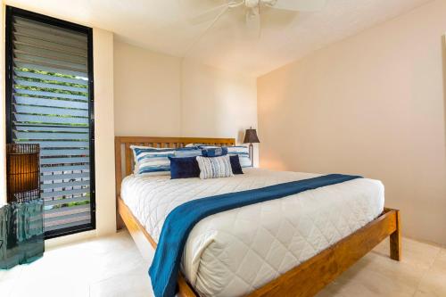 a bedroom with a bed and a large window at Maalaea Banyans 102 by Coldwell Banker Island Vacations in Wailuku
