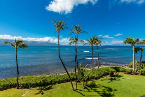 a view of the ocean from a resort with palm trees at Maalaea Banyans 102 by Coldwell Banker Island Vacations in Wailuku