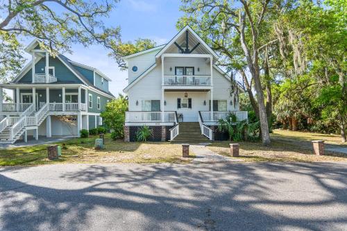 a large white house with a porch and a driveway at Lloyd's Lodge at Davis Love Dr in Fripp Island