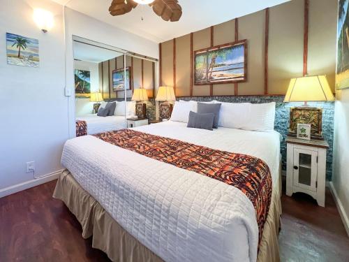 a hotel room with a large bed and a mirror at Maalaea Kai 215 by Coldwell Banker Island Vacations in Wailuku