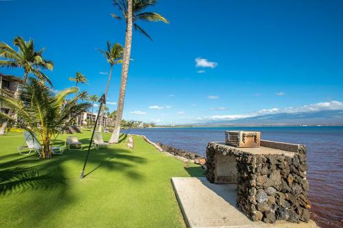 a resort with palm trees and a body of water at Maalaea Kai 215 by Coldwell Banker Island Vacations in Wailuku
