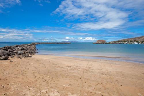 a sandy beach with rocks and the ocean at Maalaea Kai 215 by Coldwell Banker Island Vacations in Wailuku