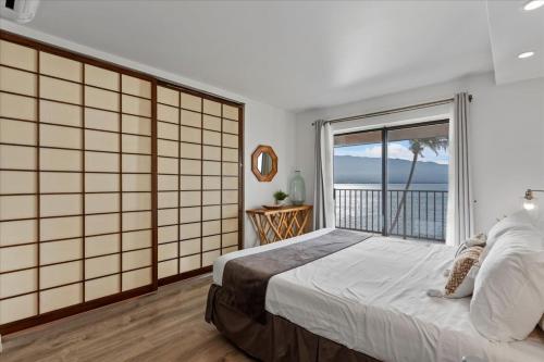 a bedroom with a bed and a large window at Lauloa 407 by Coldwell Banker Island Vacations in Wailuku