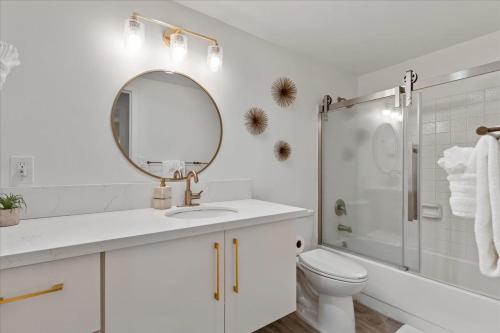 a white bathroom with a sink and a mirror at Lauloa 407 by Coldwell Banker Island Vacations in Wailuku