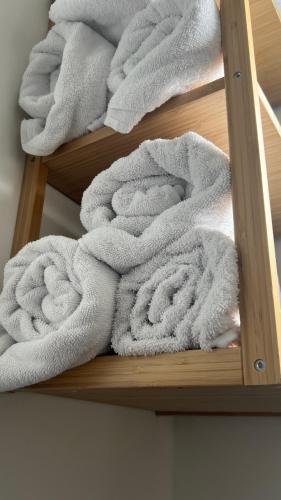 a pile of white towels on a wooden shelf at Heerlijk appartement Centrum Breda en restaurant! in Breda