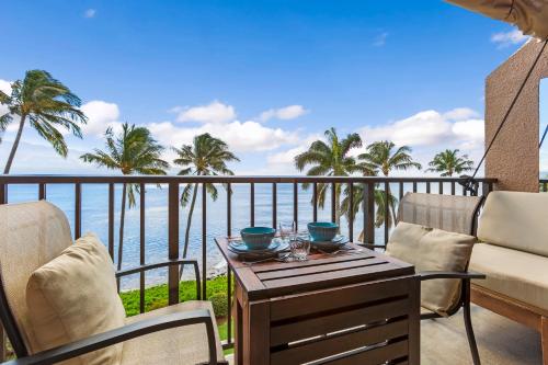 a balcony with a table and chairs and the ocean at Maalaea Banyans 416 by Coldwell Banker Island Vacations in Wailuku