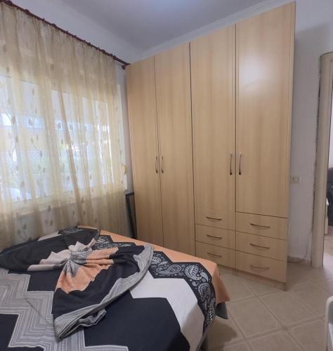 a bedroom with a bed and some wooden cabinets at Beautiful Villa at Lura 1, Gjiri Lalzit in Durrës