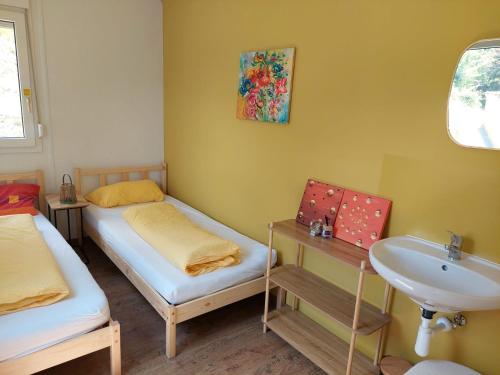 a small room with two beds and a sink at Weitblick Hof Tiny House in Sankt Paul im Lavanttal