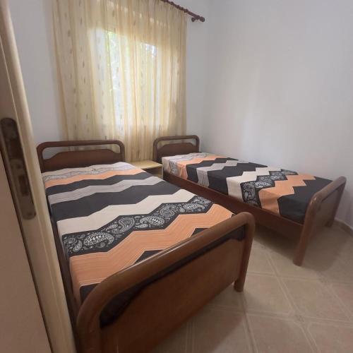 two beds sitting in a room with a window at Beautiful Villa at Lura 1, Gjiri Lalzit in Durrës
