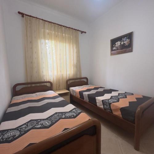 two beds sitting in a room with a window at Beautiful Villa at Lura 1, Gjiri Lalzit in Durrës