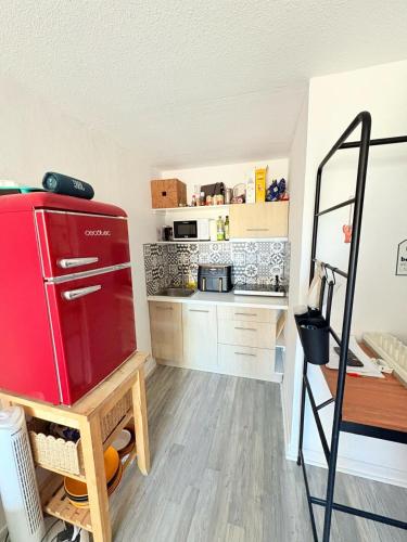 Elle comprend une petite cuisine équipée d'un réfrigérateur rouge. dans l'établissement Joli T2 lumineux, proche des plages, à Sète