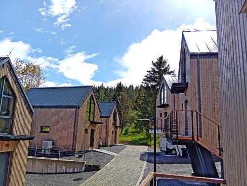 a row of wooden houses with a pathway at Bobrí potôčik in Liptovský Mikuláš