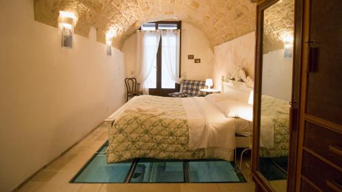 ein Schlafzimmer mit einem Bett in einem Zimmer mit einem Fenster in der Unterkunft B&B Al Duomo in Mola di Bari