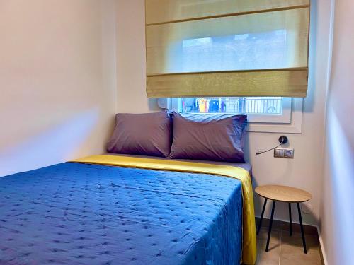 a small bedroom with a blue bed with a window at Villa Maria Petru in Ierissos