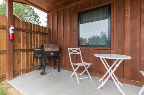 a patio with a grill and a table and chairs at Gold Valley Camp Cabin 3 in Custer