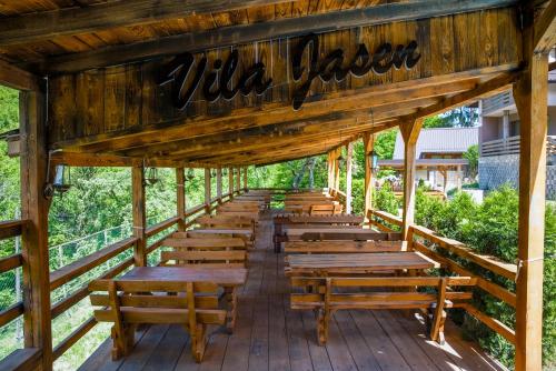 a row of wooden benches on a deck at Vila Jasen - Bjelašnica in Sarajevo