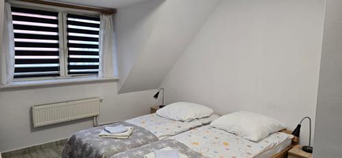 a bedroom with two beds and a window at Dom Gościnny Koinonia in Mrągowo